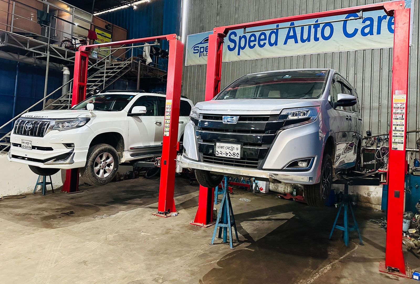 Toyota Land Cruiser and Toyota Noah on two-post lifters at Speed Auto Care